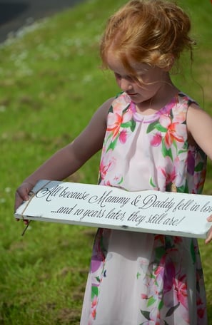 Young girl holding a sign for Mommy & Daddy