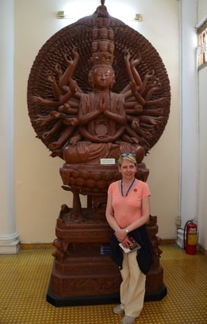 Lady Michelle poses in front of a wooden sculpture at the history museum, Ho Chi Minh City, Vietnam