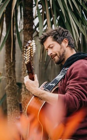 a man playing guitar in a garden