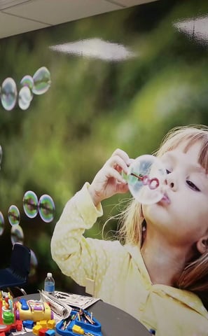 Custom graphics of a little girl blowing bubbles for a children's play area at a car dealership