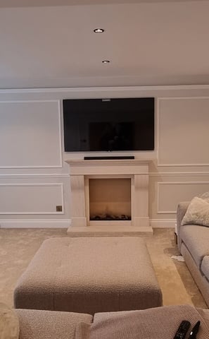 TV mounted on a wall above a fireplace with concealed cables