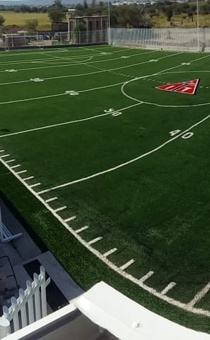 Pasto sintético de alta calidad instalado en una cancha de futbol americano en UVM