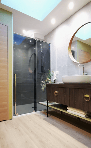 Salle de bains avec douche italienne, portes coulissante. Meuble bois, vasque blanche posée sur plan