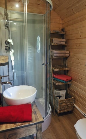Intérieur de la roulotte, salle d'eau compacte avec douche, lave main et wc
