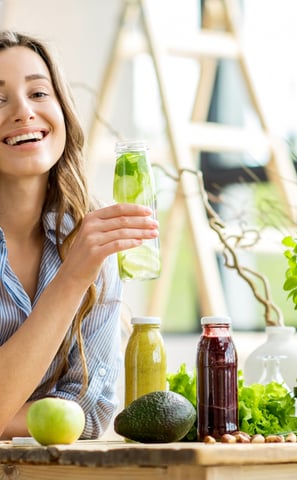a woman sitting at a table with a glass of juice
