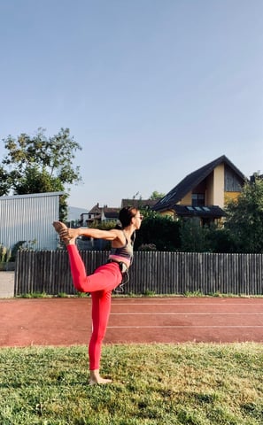 a woman in a red sports bra top doing yoga