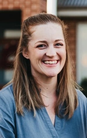 a smiling image of Amy Keeble, coach at Next Chapter Coaching, with long hair and a blue shirt