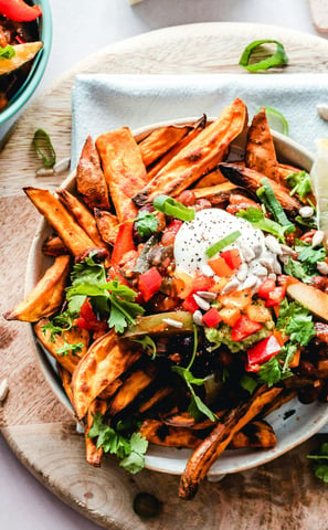 Golden fries topped with a generous amount of garnishing.