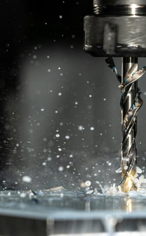 CNC machine is drilling a piece of metal