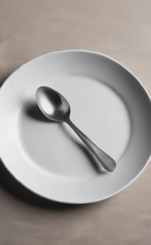A minimalist arrangement of kitchenware items on a pastel pink background, including a green ceramic dish with a wooden spoon, a ribbed green cup on a bamboo board, a lidded green ceramic container, and a bowl filled with coffee beans.