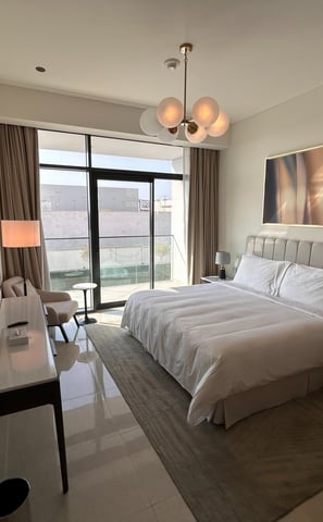 a bedroom with a bed and a large window