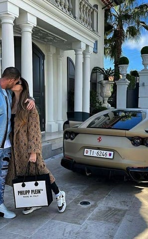 a man and woman kissing in front of a car