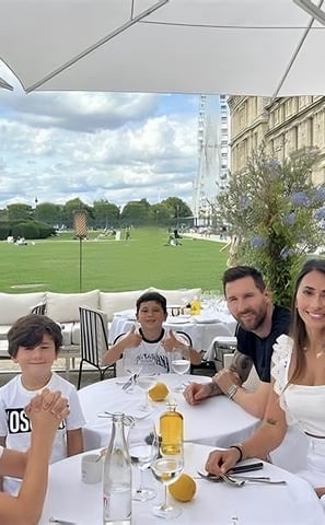 a family sitting at a table with a man and two children