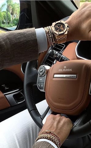 a man driving a car with a watch on his wrist