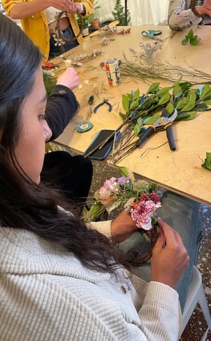 a woman is making a flower arrangement for a wreath