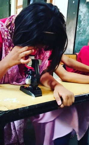 student using microscope