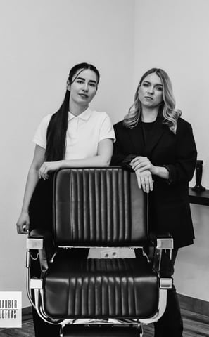 two women standing in front of a hair salon