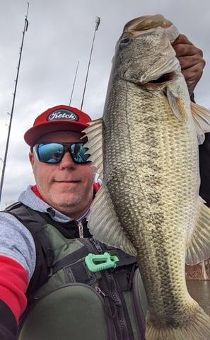 a man holding a large fish on a kayak