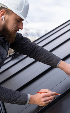 un ouvrier en rénovation énergétique construit une toiture moderne