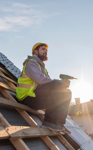 un ouvrier en rénovation énergétique construit une toiture
