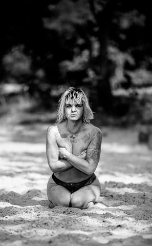 a woman sitting on a beach with her arms crossed and arms crossed