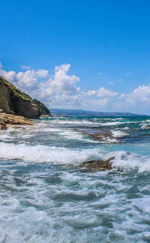 a person is surfing on a rocky beach
