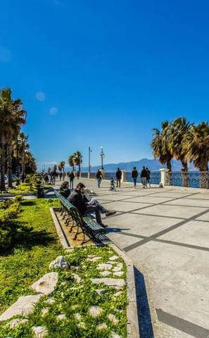 a bench with people sitting on benches near the water