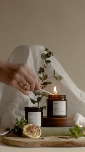 a person holding a candle in front of a wooden board