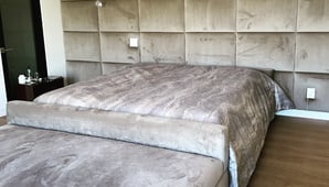 Upholstered bed with velvet wall panels in a modern bedroom by Solo Home Decor.