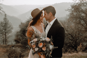 a man and woman standing in front of a mountain