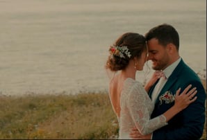 Moment complice des mariés enlacés au bord de la mer, capté par une vidéaste de mariage