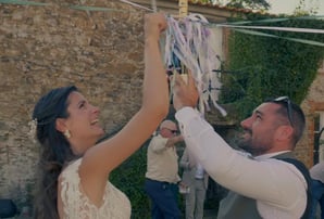Mariés participant à la ronde des rubans autour du bouquet lors de leur mariage