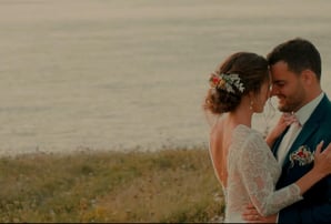 Moment complice des mariés enlacés au bord de la mer, capté par une vidéaste de mariage