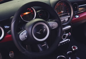 a car dashboard with a steering wheel and dashboard controls