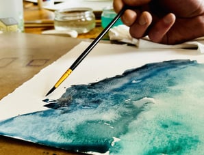 artiste qui peint un paysage à l'aquarelle