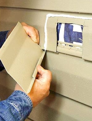 a man is putting a piece of paper in a hole in the wall