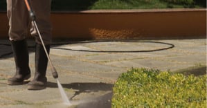 man cleans stone floor with high pressure lance. photo by Sincegameon