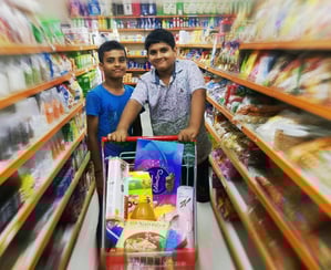 two men standing in a store with a carton
