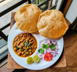a plate of food with a bowl of food on a table, chole bhaature