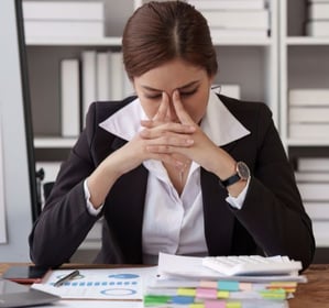 a woman in a business suit sitting at a desk