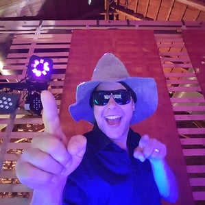 Hochzeit DJ Markus aus Bayern tanzt mit Hut und Sonnenbrille hinter seinem Mischpult