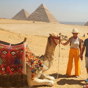 casal de turistas brasileiros tirando foto com camelo na area das piramides de gize acompanhados pelo guia hadi , passeio nas