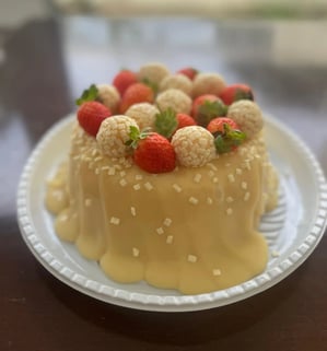 Deliciosa sobremesa com cobertura de doce de leite, decorada com morangos e bombons brancos, ideal p