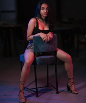 a Lanka Ads woman in a black dress sitting on a chair