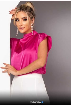 a woman in a pink top and white pants