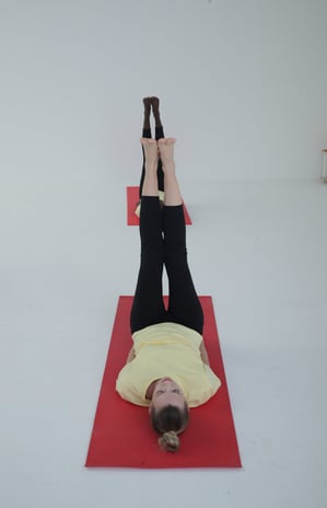 a women doing yoga with yellow tshirt and black pants