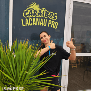 Pauline Royer posant devant le logo du Lacanau Pro