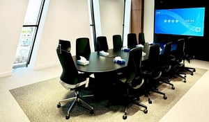 Modern meeting room with black mesh chairs and presentation screen