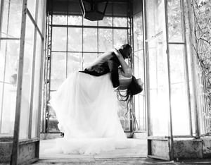 Black and white photo of elopement couple dancing in a glass greenhouse in Provence