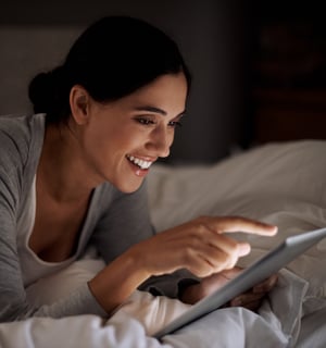 a woman is smiling and holding a tablet computer